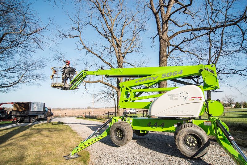 tree service in Fort Wayne, Indiana; person on green lift for tree trimming and tree removal